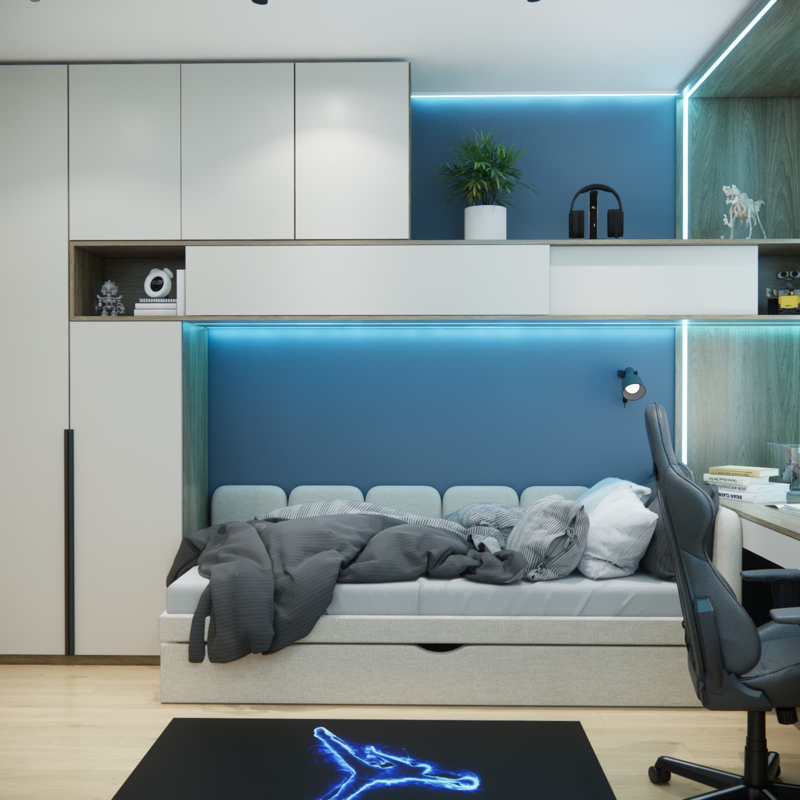 Bed with a storage drawer against a blue wall and light-coloured cabinets with lighting above the sleeping area